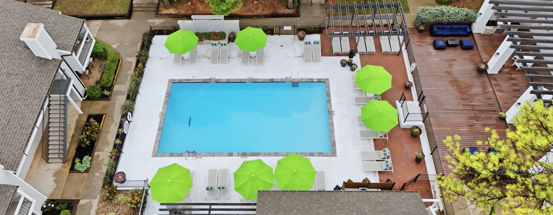 Areil View of Pool and Community overseeing Loungers and Umbrellas
