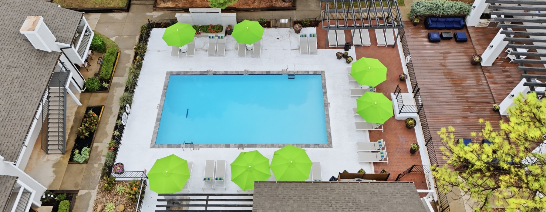 Areil View of Pool and Community overseeing Loungers and Umbrellas