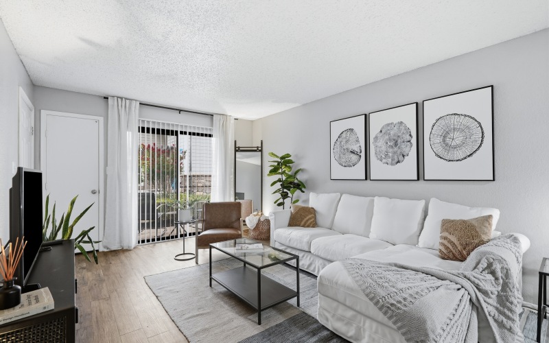 Livingroom with hardwood flooring, overlooking patio, with chair, couch, table, entertainment center 