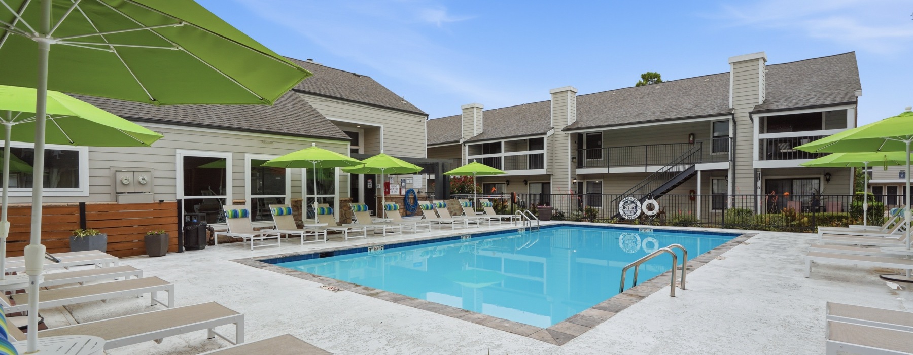 Community Pool with tanning loungers and umbrellas