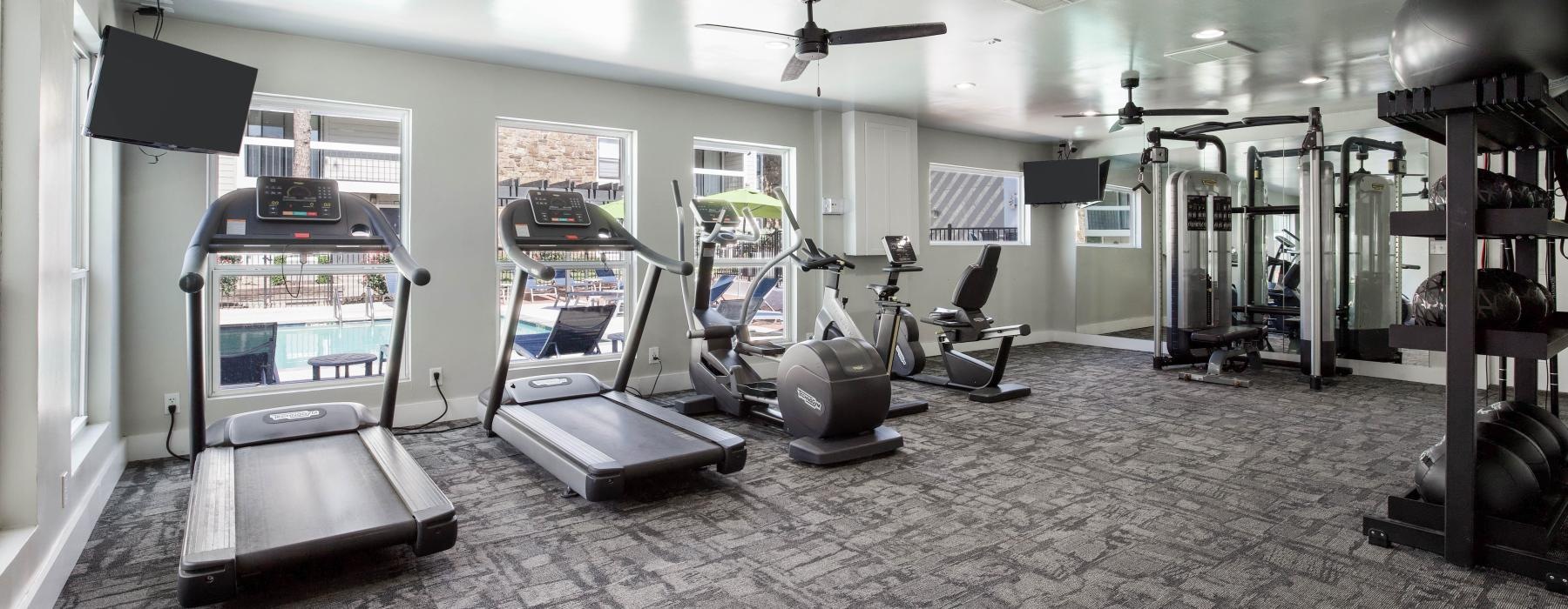 gym with treadmills and pool views